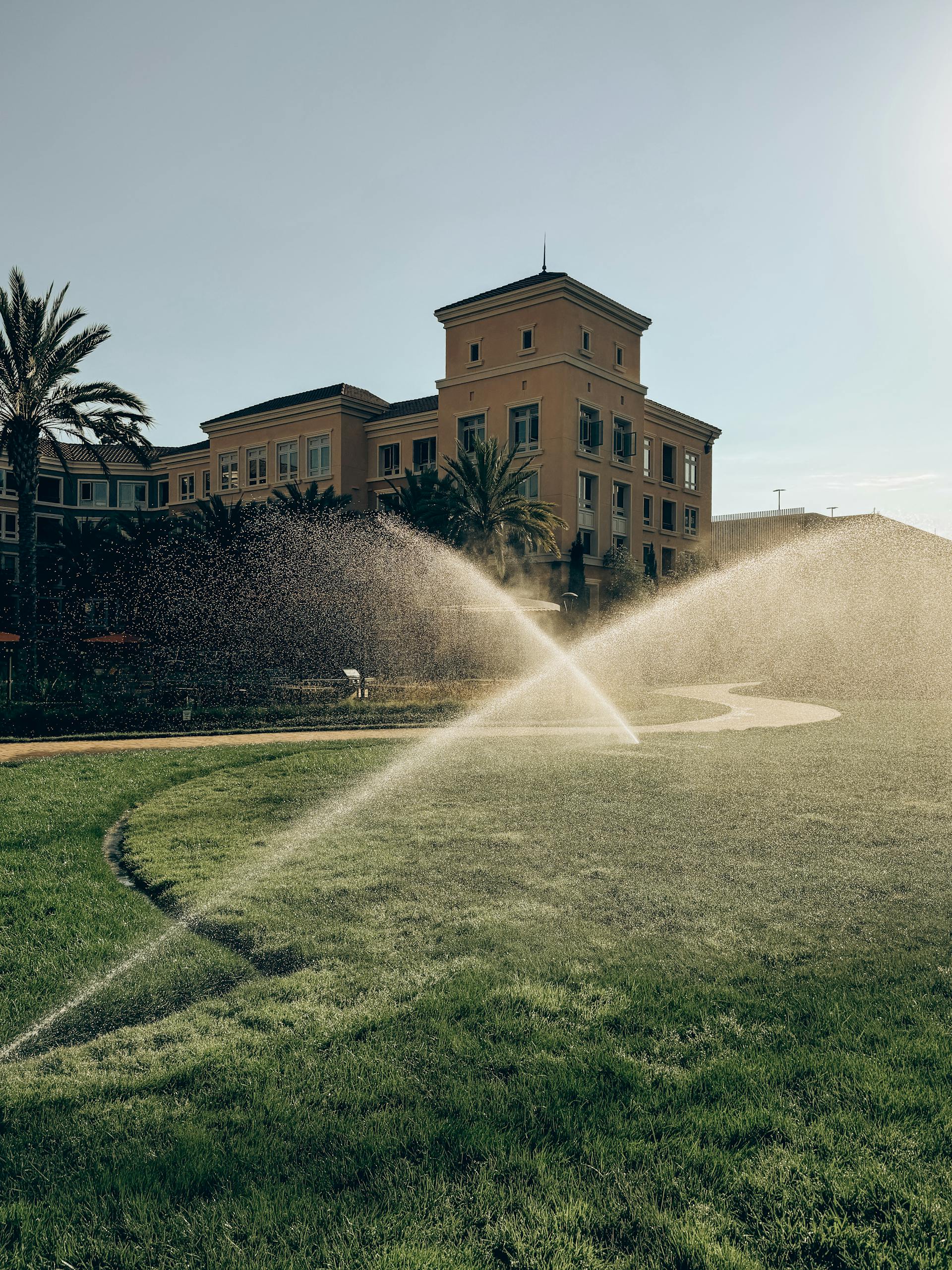 Commercial sprinkler system watering green lawn